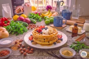 Easy healthy protein waffles topped with fresh berries, banana slices, Greek yogurt, and maple syrup
