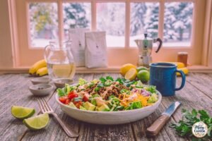 Keto taco salad with seasoned ground beef, avocado, cheddar cheese and fresh vegetables